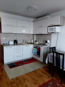 een keuken met witte kasten en een fornuis met oven bij Прекраснные апартаменты с панорамным видом на море in Byala