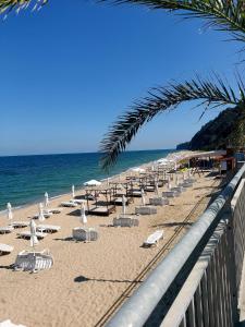 een strand met stoelen en parasols en de oceaan bij Прекраснные апартаменты с панорамным видом на море in Byala
