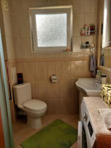 een badkamer met een toilet, een wastafel en een raam bij Прекраснные апартаменты с панорамным видом на море in Byala