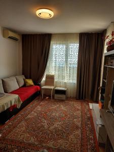 een woonkamer met een bed en een tapijt bij Прекраснные апартаменты с панорамным видом на море in Byala