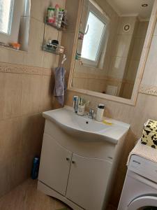 een badkamer met een witte wastafel en een spiegel bij Прекраснные апартаменты с панорамным видом на море in Byala