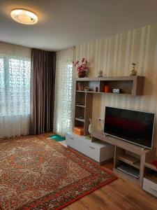 een woonkamer met een flatscreen-tv en een tapijt bij Прекраснные апартаменты с панорамным видом на море in Byala