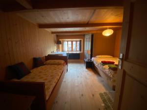 ein kleines Zimmer mit 2 Betten und einem Fenster in der Unterkunft Casa Vegana in Trun