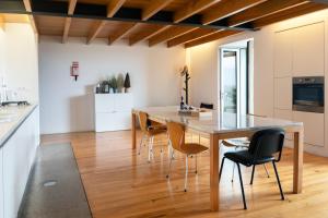una cucina e una sala da pranzo con tavolo e sedie in legno di Casa Mar Adentro a Câmara de Lobos