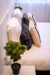 a row of pillows on a bed with a plant at Hôtel Gallia Cannes in Cannes
