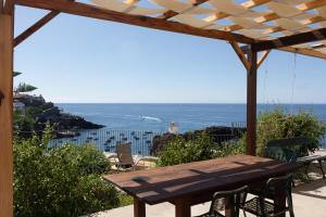 a wooden table with chairs and a view of the ocean at Casa Mar Adentro in Câmara de Lobos