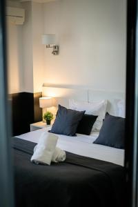 a bedroom with a large bed with blue and white pillows at Hôtel Gallia Cannes in Cannes