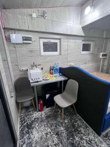 キシナウにあるStandart roomsのトレーラーに椅子2脚とテーブル1台が備わる部屋