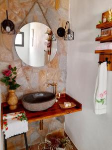 y baño con lavabo de piedra y espejo. en CASA RURAL EL TRASTERO DE CARMELO, en Maello