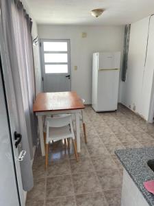 a small kitchen with a table and a refrigerator at ALOJAMIENTO ONCATIVO in Oncativo