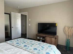 um quarto com uma cama e uma televisão de ecrã plano em Hidden Oasis, Duplex A. Close to almost everything em Lincoln
