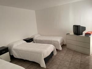 Habitación de hotel con 2 camas y TV en ALOJAMIENTO ONCATIVO en Oncativo