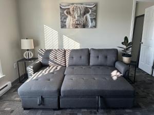 uma sala de estar com um sofá e uma imagem de uma vaca em Hidden Oasis, Duplex A. Close to almost everything em Lincoln