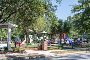 a park with a playground with slides and swings at Encanto of the Lowcountry in Old Town Bluffton in Bluffton