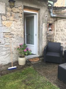 une terrasse avec une porte, une chaise et des fleurs dans l'établissement Petite maison avec jardin privé, au Malzieu-Ville