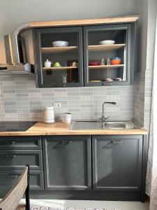 a kitchen with gray cabinets and a sink at Nido di Rina in Ponte A Bozzone