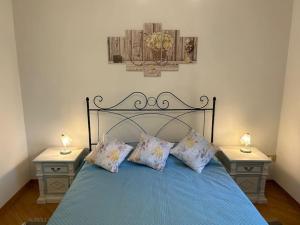 a bedroom with a blue bed with two night stands at Nido di Rina in Ponte A Bozzone