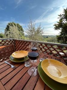 a table with two glasses of wine on a deck at Nido di Rina in Ponte A Bozzone