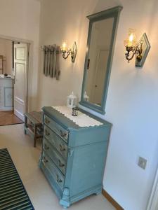 uma casa de banho com uma cómoda azul e um espelho em Nido di Rina em Ponte A Bozzone
