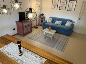 un soggiorno con divano blu e tavolo di Nido di Rina a Ponte A Bozzone
