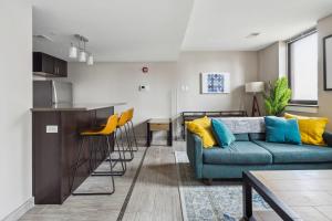 a living room with a couch and a kitchen at 2BR Executive Downtown Apartment by ENVITAE in Detroit