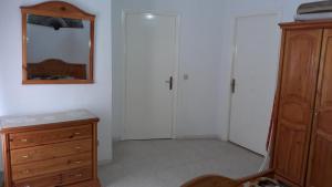 - une chambre avec un miroir, une commode et un placard dans l'établissement Ahlem palmeraies résidence, à La Marsa