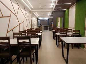 una fila di tavoli e sedie in una sala da pranzo di Hotel Satyam a Jaigaon