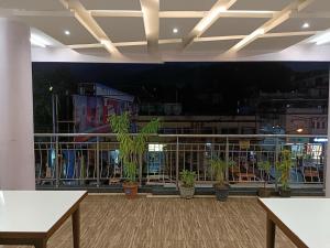 a room with tables and potted plants on a wall at Hotel Satyam in Jaigaon