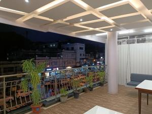 a balcony with a view of a city at night at Hotel Satyam in Jaigaon