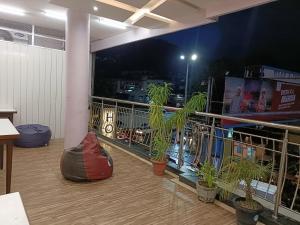 a balcony with potted plants on a building at night at Hotel Satyam in Jaigaon