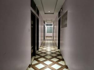 a hallway with a tile floor and a long corridor at Hotel Satyam in Jaigaon