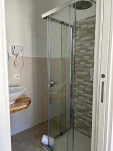La salle de bains est pourvue d'une douche en verre et d'un lavabo. dans l'établissement Il Marchesino B&B, à Pizzo