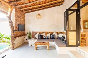 una sala de estar con un sofá y una mesa en Angatu Villas 1 Padang - Padang, en Uluwatu