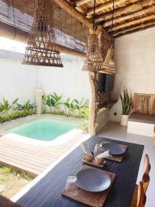 Un comedor con mesa y una piscina. en Angatu Villas 1 Padang - Padang, en Uluwatu