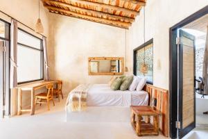 Un dormitorio con una cama, un escritorio y ventanas. en Angatu Villas 1 Padang - Padang, en Uluwatu 33 fotos más