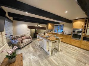 a large kitchen with a table and a couch at Large Historic Farmhouse in Rhondda Valley Perfect for Groups with Hot Tub in Blaencwm