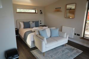 a bedroom with a bed and a couch and a chair at Angusfield Cabins in Sconser