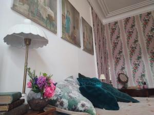 1 dormitorio con 1 cama con almohadas y lámpara en Rose's room en Saint-Léonard
