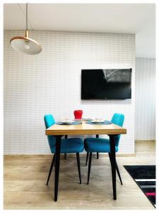 ein Esszimmer mit einem Tisch und blauen Stühlen in der Unterkunft Apartaments in the city centre in Kaunas