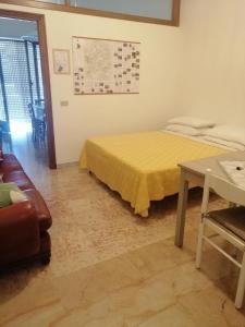 - une chambre avec un lit jaune et une table dans l'établissement Central Tourist Residence - B&B - Alloggi Temporanei Isernia, à Isernia