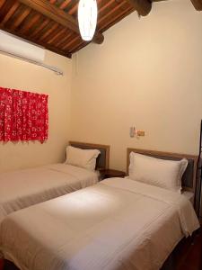 dwa łóżka siedzące obok siebie w pokoju w obiekcie Yong Le Homestay w mieście Jincheng