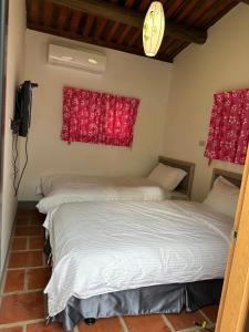 two beds in a room with red curtains at Yong Le Homestay in Jincheng