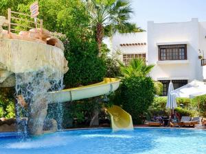 Apartments for rent in Delta Sharm Resort في شرم الشيخ: زحليقة مائية في مسبح مع نافورة