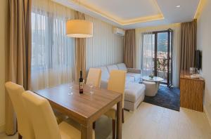a living room with a dining room table and a couch at Aparthotel Villa Aria in Budva