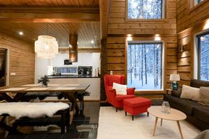 cocina y sala de estar con mesa y sillas rojas en Charming log house - Lumous B - Pyhätunturi - Finland en Pyhätunturi