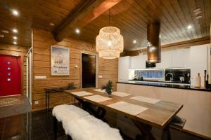 comedor con mesa y cocina en Charming log house - Lumous B - Pyhätunturi - Finland en Pyhätunturi