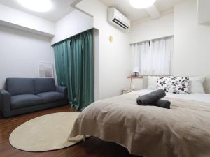 ein Schlafzimmer mit einem großen Bett und einer Couch in der Unterkunft Duo Scala Shinjuku 東新宿 in Tokio + 33 Fotos