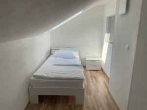 a small bedroom with a bed with white sheets at Ferienhaus in Amstetten in Amstetten