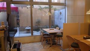 金沢市にある日月庵 BnB Sunmoonのテーブルと椅子、窓が備わる客室です。