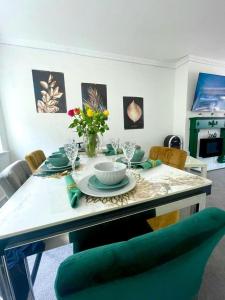 a dining room with a table with a green chair at White House Villa in Nottingham